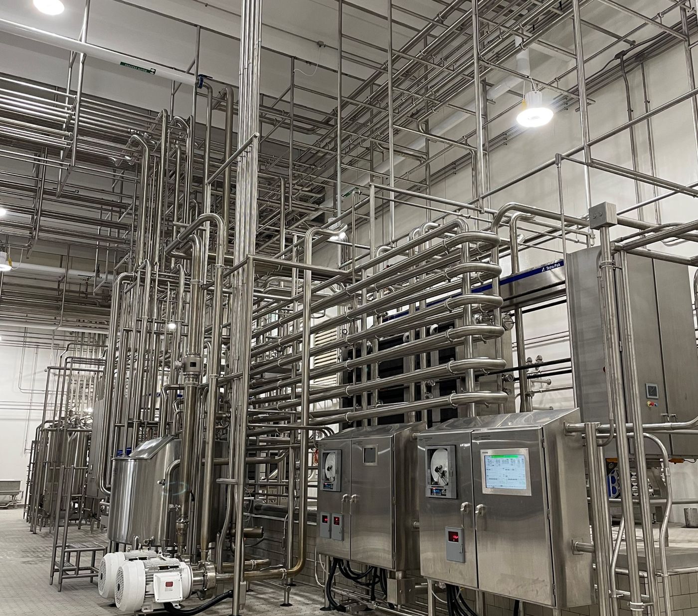 Pasteurizer skid with stainless control panels and process piping